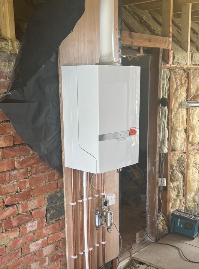 ATAG boiler fitted during a loft conversion with exposed brick and new pipework
